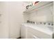 Clean and functional laundry room with white appliances and storage shelf for convenience at 6590 Williamson Ne Dr, Atlanta, GA 30328