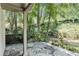 Cozy stone patio that overlooks a lush backyard with mature trees and flowing creek, creating a serene outdoor space at 6590 Williamson Ne Dr, Atlanta, GA 30328