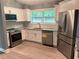 Bright kitchen featuring stainless steel appliances, granite countertops, and white cabinets at 6832 Shangrila Way, Riverdale, GA 30296