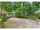 Large backyard with a driveway, fence, and greenery creating a private and serene outdoor space at 11190 Hembree Springs Dr, Roswell, GA 30076