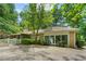 A backyard featuring a well-maintained lawn, mature trees, brick accents, and a white picket fence at 11190 Hembree Springs Dr, Roswell, GA 30076