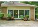 Patio doors open onto backyard with beautiful landscaping, brick accents, potted plants, and mature trees at 11190 Hembree Springs Dr, Roswell, GA 30076