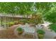 Backyard boasts a charming patio with white wicker seating, mature trees, and manicured landscaping creating an inviting oasis at 11190 Hembree Springs Dr, Roswell, GA 30076