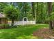 Well-manicured backyard with a white picket fence, lush trees, and green grass at 11190 Hembree Springs Dr, Roswell, GA 30076