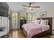 Comfortable bedroom with a ceiling fan, hardwood floors, and plenty of natural light at 11190 Hembree Springs Dr, Roswell, GA 30076