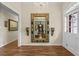 Foyer featuring wood floors, a large ornate mirror, wall sconces, and a white front door at 11190 Hembree Springs Dr, Roswell, GA 30076