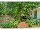 Backyard garden area featuring a quaint outbuilding, raised garden beds, and lush green landscaping at 11190 Hembree Springs Dr, Roswell, GA 30076
