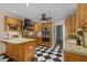 Kitchen boasts wood cabinets, stainless steel appliances, granite countertops, and black and white tile flooring at 11190 Hembree Springs Dr, Roswell, GA 30076