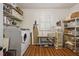 The laundry room has a washer and dryer, shelving, a window, and a table at 11190 Hembree Springs Dr, Roswell, GA 30076