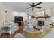 Inviting living room featuring a fireplace, tv, ceiling fan, and comfortable white seating at 11190 Hembree Springs Dr, Roswell, GA 30076