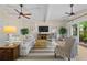 Bright living room with vaulted ceiling, ceiling fans, and backyard views at 11190 Hembree Springs Dr, Roswell, GA 30076