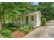 Quaint outbuilding with porch offers a secluded retreat surrounded by lush greenery at 11190 Hembree Springs Dr, Roswell, GA 30076