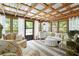 Cozy sunroom with exposed rafters, cushioned seating and plenty of natural light at 11190 Hembree Springs Dr, Roswell, GA 30076