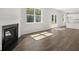 Cozy living area with fireplace, wood flooring, and window looking out on mature trees at 3941 Fairhaven Rd, Lithia Springs, GA 30122