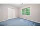 Carpeted bedroom featuring large closet and window views of the outside greenery at 3 Maplelake Dr, Acworth, GA 30101
