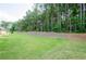 Spacious backyard features lush green grass and wooded area, offering privacy and outdoor enjoyment at 3405 Linstead Ct, Loganville, GA 30052