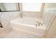 Modern bathroom features a soaking tub with a handheld shower, decorative tile and an adjacent shower at 3405 Linstead Ct, Loganville, GA 30052