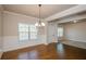 Dining room featuring hardwood floors, wainscoting, and view into carpeted living area at 3405 Linstead Ct, Loganville, GA 30052