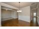 Open-concept dining room featuring hardwood floors and a view into a carpeted living area at 3405 Linstead Ct, Loganville, GA 30052