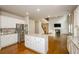 Open kitchen with stainless steel appliances, an island, and hardwood floors leading to the living area at 3405 Linstead Ct, Loganville, GA 30052