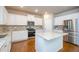 Modern kitchen with white cabinets, stainless steel appliances, granite countertops and hardwood floors at 3405 Linstead Ct, Loganville, GA 30052