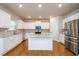 Bright kitchen with white cabinetry, stainless steel appliances, a center island, and hardwood floors at 3405 Linstead Ct, Loganville, GA 30052