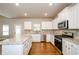 Bright kitchen with white cabinets, granite countertops, tile backsplash, and stainless steel appliances at 3405 Linstead Ct, Loganville, GA 30052
