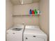 Laundry room equipped with full-size washer and dryer and a shelf for storage at 3405 Linstead Ct, Loganville, GA 30052