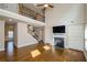 Open living room with hardwood floors, fireplace, built-in shelving, and staircase to upper level at 3405 Linstead Ct, Loganville, GA 30052