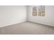 An empty bedroom with plush carpeting and a view of the surrounding trees at 3933 Fairhaven Rd, Lithia Springs, GA 30122