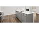 Kitchen island with stainless steel sink and gray cabinets, connecting to living space at 3933 Fairhaven Rd, Lithia Springs, GA 30122