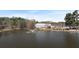 Picturesque pond view with a fountain, trees, event building, and parking area at 3933 Fairhaven Rd, Lithia Springs, GA 30122