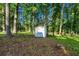Backyard featuring a storage shed, mature trees, and a grassy area at 4274 Smithsonia Ct, Tucker, GA 30084