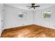 Bright bedroom with hardwood floors, two windows, and a modern ceiling fan at 4274 Smithsonia Ct, Tucker, GA 30084