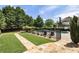 Well-maintained backyard with a fenced pool, manicured lawn, beautiful landscaping, and a stone patio at 4830 Westgate Dr, Cumming, GA 30040