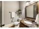 Charming half bathroom featuring a marble countertop and decorative mirror at 4830 Westgate Dr, Cumming, GA 30040
