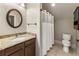 Bathroom featuring a granite countertop vanity, tile floors, round mirror and shower-tub combo at 4830 Westgate Dr, Cumming, GA 30040