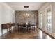 Elegant dining room with hardwood floors, brick accent wall, a chandelier, and large windows at 4830 Westgate Dr, Cumming, GA 30040