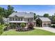 Beautiful brick home featuring a covered porch, manicured lawn, and three car garage at 4830 Westgate Dr, Cumming, GA 30040
