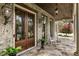 Charming front porch with decorative iron door, stone floor, rocking chairs, and lush plants at 4830 Westgate Dr, Cumming, GA 30040