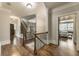Bright hallway boasts hardwood floors, decorative staircase, and access to a bedroom with natural light at 4830 Westgate Dr, Cumming, GA 30040