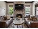 Inviting living room featuring a stone fireplace, wooden beam accents, and comfortable leather seating at 4830 Westgate Dr, Cumming, GA 30040