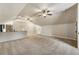 Spacious living room featuring neutral carpet, ceiling fans, vaulted ceilings and a kitchen area at 4830 Westgate Dr, Cumming, GA 30040