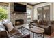 Inviting living room featuring a stone fireplace, wooden beam accents, and comfortable leather seating at 4830 Westgate Dr, Cumming, GA 30040