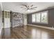 Spacious living room featuring a stone accent wall, built-in shelving, and ample natural light from large windows at 4830 Westgate Dr, Cumming, GA 30040
