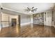Open-concept living area featuring a stone wall, custom built-ins, and hardwood floors with staircase access at 4830 Westgate Dr, Cumming, GA 30040