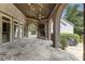 Relaxing covered porch features an outdoor fireplace, stone flooring, and backyard views at 4830 Westgate Dr, Cumming, GA 30040