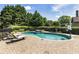 Sparkling in-ground pool with waterfall feature, surrounded by brick patio and mature landscaping at 4830 Westgate Dr, Cumming, GA 30040