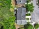 Aerial view of the rear of the townhome, showing deck, landscaping and proximity to other homes and roads at 2138 Mill Garden Run, Buford, GA 30519
