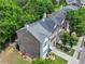 Aerial shot of the rear exterior of the townhome with a deck and patio, showcasing the well-maintained landscaping at 2138 Mill Garden Run, Buford, GA 30519